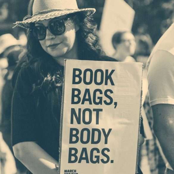 #MarchForOurLives protestor holding 'book bags, not body bags' sign