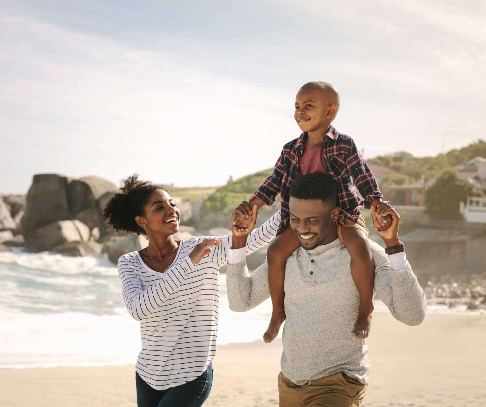 family of three enjoy walk on beach