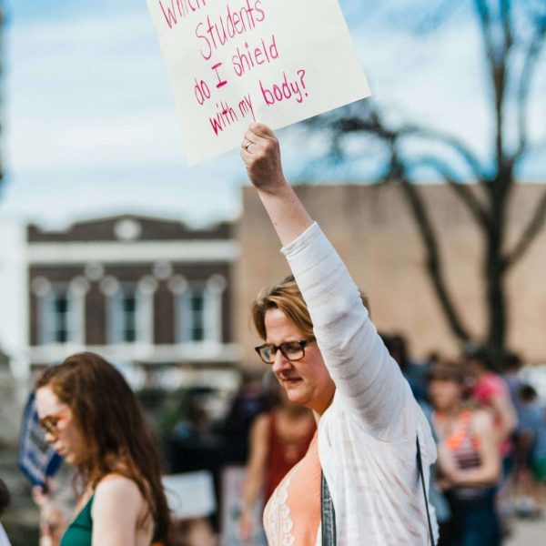 teacher protest holding sign 'which of my students do I shield with my body'